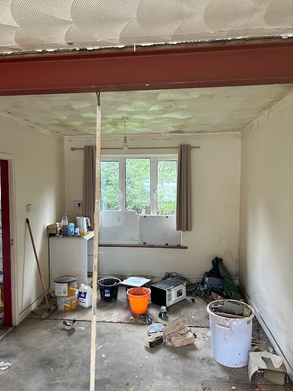 The white room before, with a steel beam and the old ceiling